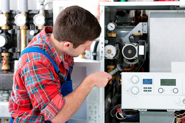 Heating technician repairing boiler controls in Sacramento