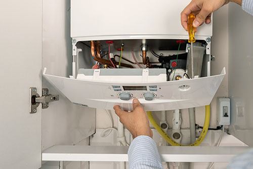Heating technician repairing a residential boiler in Sacramento