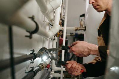 Technician inspecting commercial plumbing pipes in Sacramento