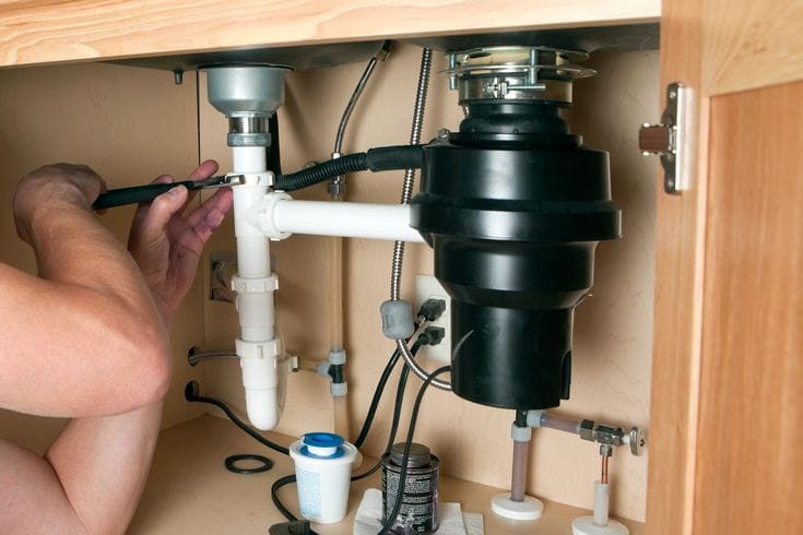 Plumber repairing a garbage disposal in Sacramento