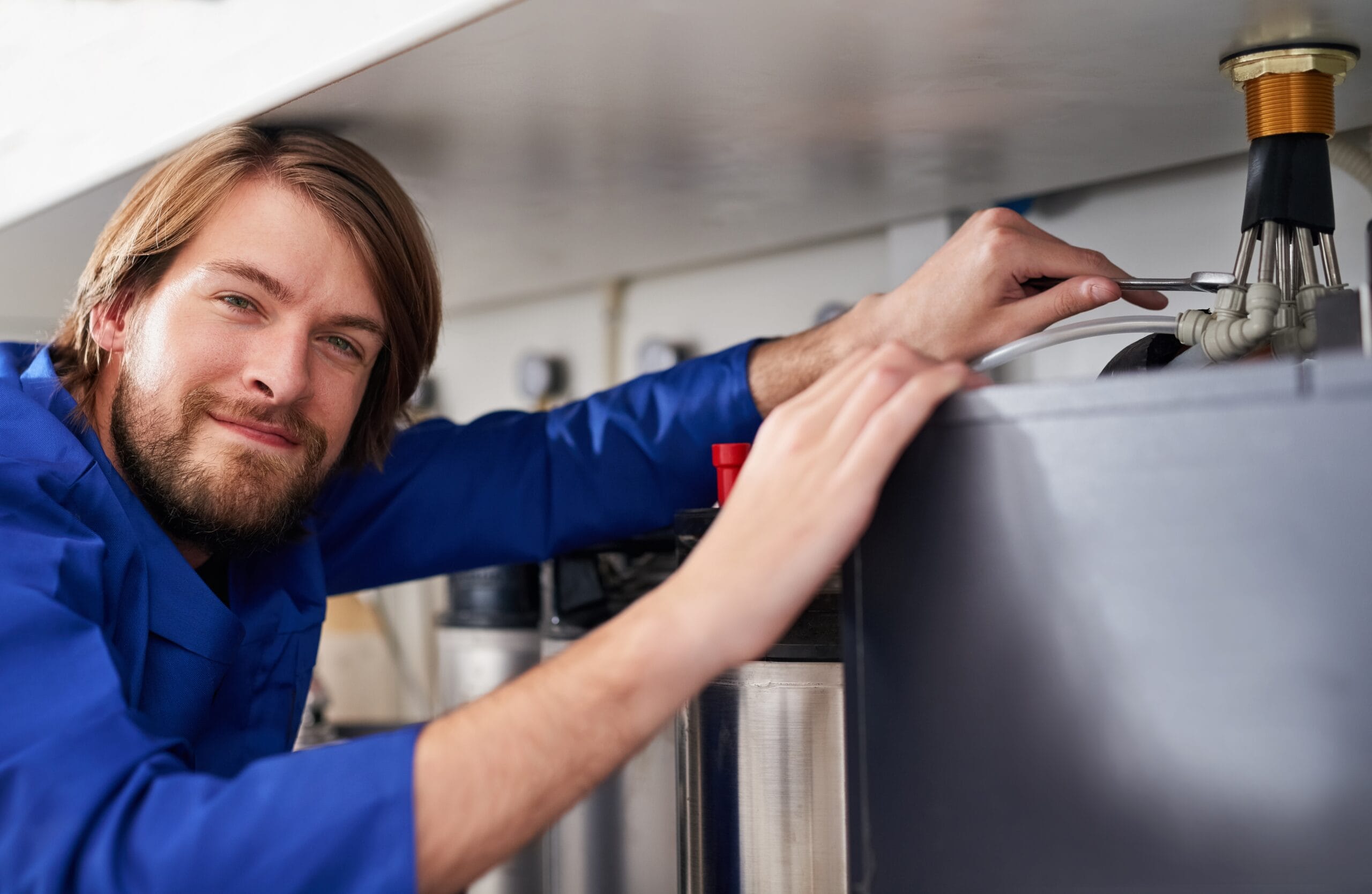 Technician servicing a residential water heater tank in Sacramento